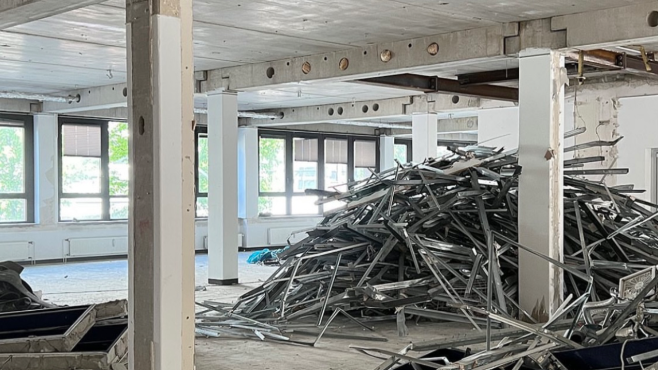 Commercial office floor soft stripped back to structure with metal ceiling grid stacked for recycling